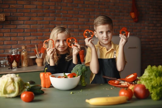 children-in-the-kitchen-holding-slices-of-capsicum-3984735