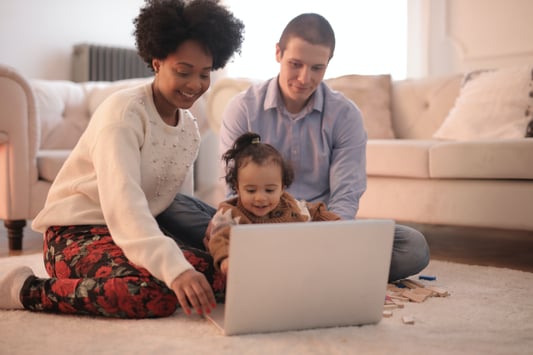 photo-of-family-sitting-on-floor-while-using-laptop-3818963
